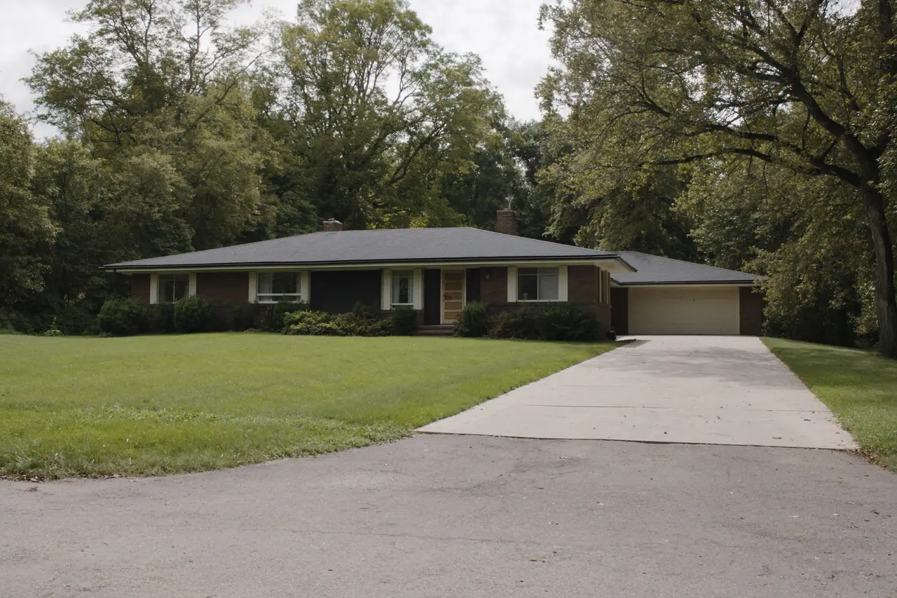 Rendered image of a 1960s ranch house on a wooded acre lot