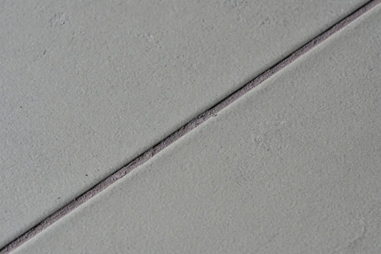 Close-up of grey ceramic tile and a grout joint
