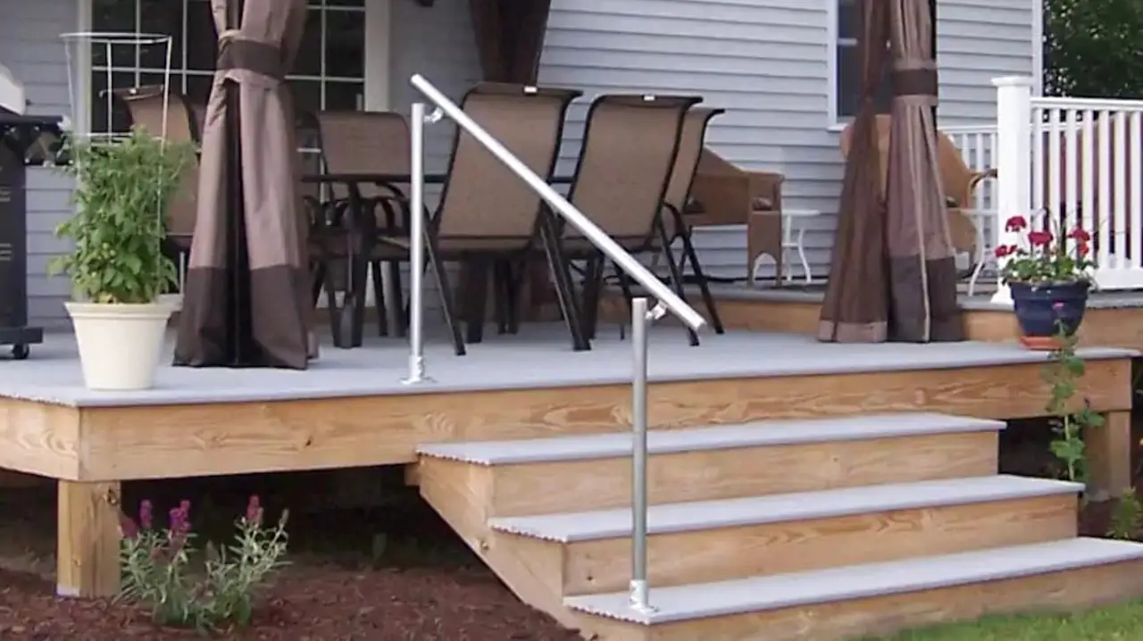 Finished deck with stairs, a pipe handrail, patio furniture and planters.