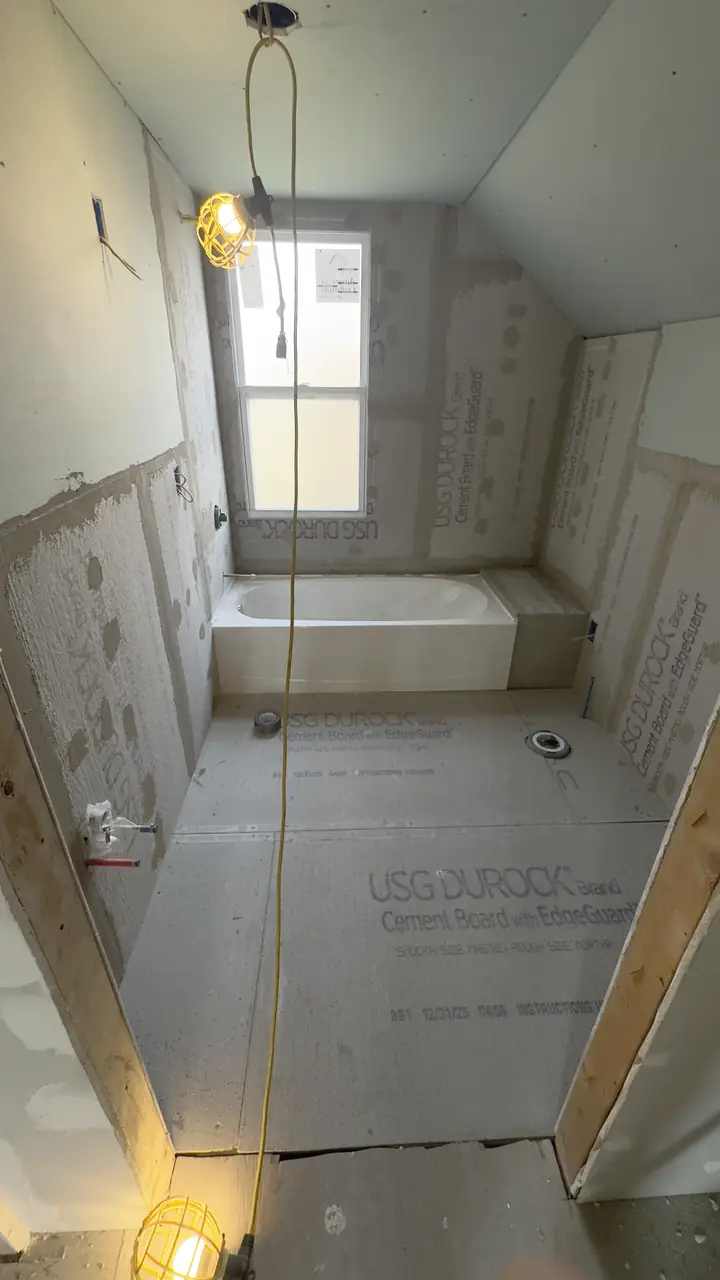 Cement board on the walls and a tub set in a framed bathroom.